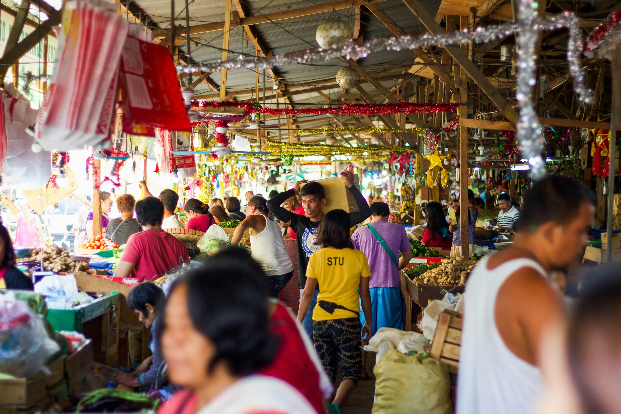 Friendly locals interacting at a bustling wet market in Cebu.